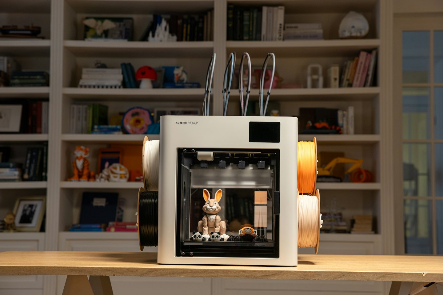 Stampante 3D su un tavolo che stampa statuette.
